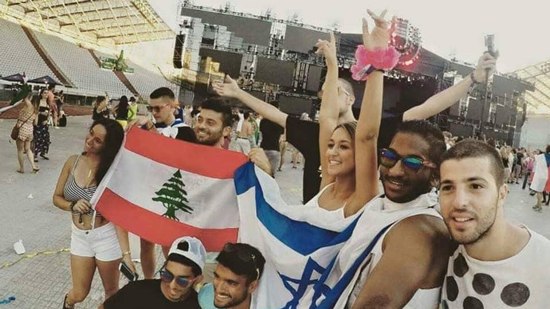 شباب من إسرائيل ومن لبنان يلوحون بإعلام البلدين ومتابعة